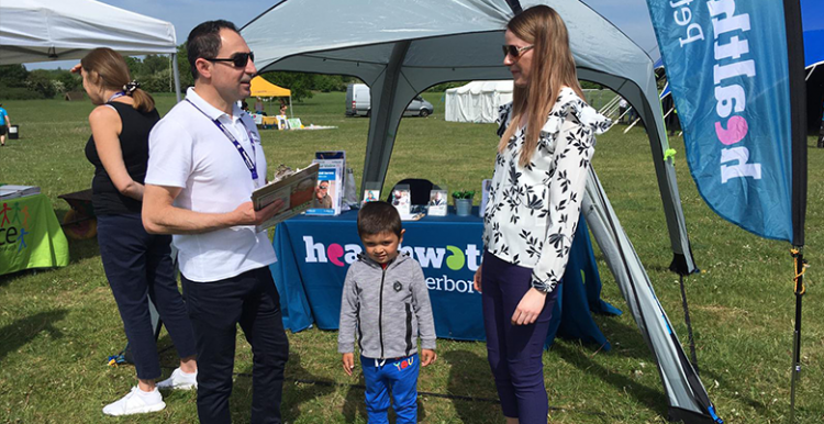 Healthwatch team member Rebwar talking to a mother and child in Ferry Meadows, Peterborough