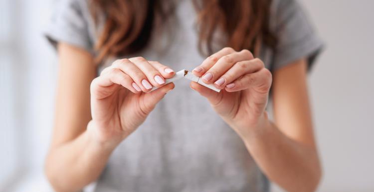 A woman snapping a cigarette in half