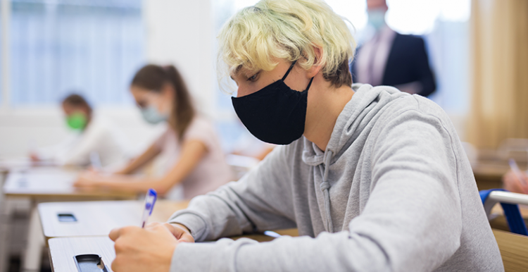 Picture shows young people wearing face coverings in classroom setting