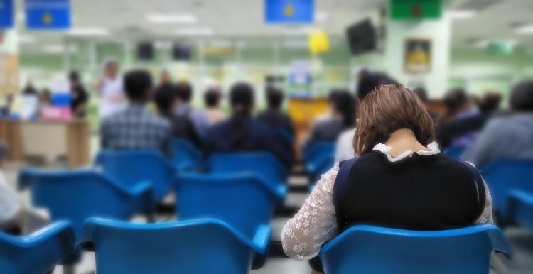 People sitting in the waiting area of a medical centre. 