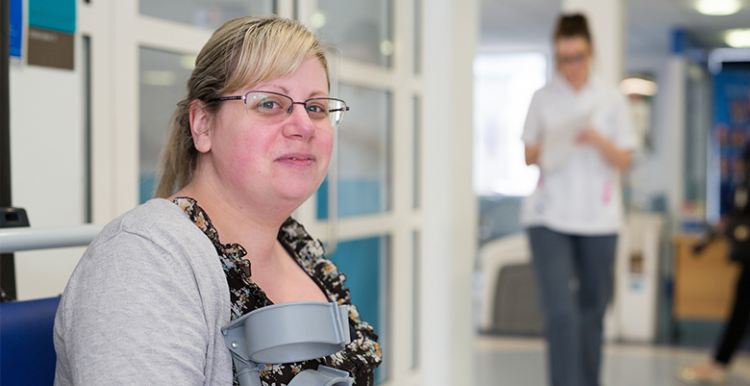 Woman with crutches in hospital waiting room