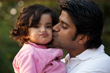 Man cuddling his toddler daughter 