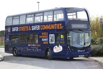 Double decker bus with 'Safer Streets and Safer Communities' campaign message written on its side